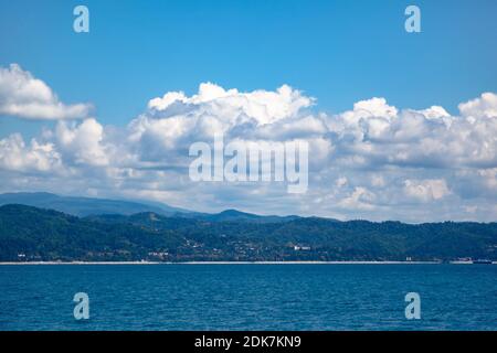 Mare e montagne contro il cielo blu Foto Stock