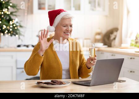 Felice vecchia signora che celebra il Natale con la sua famiglia online Foto Stock