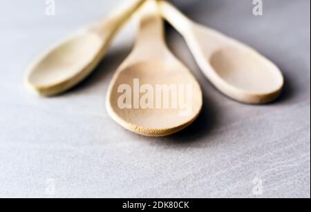 Gruppo di cucchiai da cucina in legno disposti su un tavolo in marmo grigio. Utensili da cucina e cucina. Materiale di legno Foto Stock