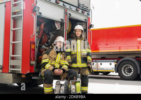 I vigili del fuoco nella parte anteriore del camion dei pompieri Foto Stock