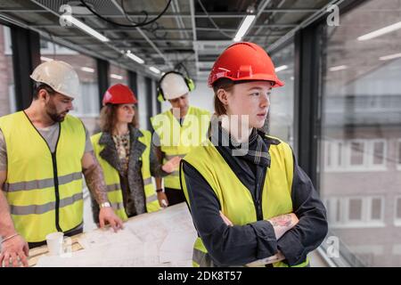 Lavoratore di sesso femminile che indossa hardhat Foto Stock