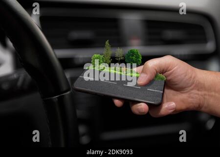 Chiamata telefonica con il telefono cellulare al volante, croce in un luogo di incidente Foto Stock