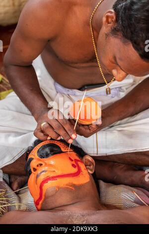 Il prete indù si adduca per l'esecutore di Theyyam durante il tempio festival Foto Stock