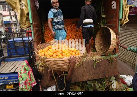 Guwahati, Assam, India. 14 dicembre 2020. Lavoro portare arance di frutta di stagione in un cesto di bambù che è portato dal vicino stato Arunachal Pradesh a Fancy Bazar in Guwahati Assam India il Martedì 15 dicembre 2020 Credit: Dasarath Deka/ZUMA Wire/Alamy Live News Foto Stock