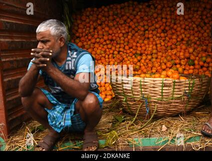 Guwahati, Assam, India. 14 dicembre 2020. Il lavoro prende una pausa dopo aver smistato le arance di frutta di stagione da un camion che è portato dal vicino stato Arunachal Pradesh a Fancy Bazar a Guwahati Assam India il martedì 15 dicembre 2020 Credit: Dasarath Deka/ZUMA Wire/Alamy Live News Foto Stock