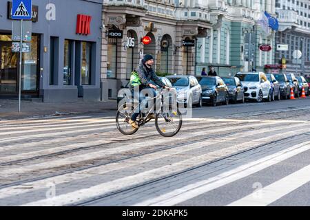 Riga, Lettonia - 6 novembre 2020: Il ciclista attraversa la strada su un passaggio pedonale Foto Stock