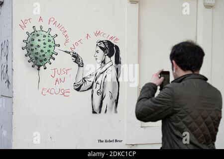 Edimburgo, Scozia, Regno Unito. 15 dicembre 2020. Street art della vaccinazione di Covid-19 da parte dell'artista di strada l'Orso Rebel di Edimburgo è vandalizzato dal protestore anti-vaccinazione. Iain Masterton/Alamy Live News Foto Stock