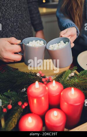 Due bicchieri di cacao fatti in casa con marshmallows. Bevanda calda invernale su sfondo di legno decorata con bastoni di cinamon e rami di abete Foto Stock