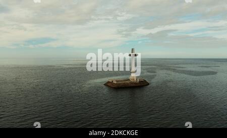 Croce cattolica nel cimitero affondata nel mare al tramonto, antenna fuco. Grandi crucafix segnando il sottomarino sunken cimitero, CAMIGUIN ISLAND Filippine. Foto Stock