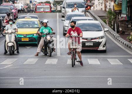 Una donna su una bicicletta si vede indossare una maschera facciale mentre attende i semafori per lasciarla andare a Bangkok.la gente indossa maschere protettive mentre l'inquinante dell'aria PM2.5 sale a livelli malsani a Bangkok. Foto Stock