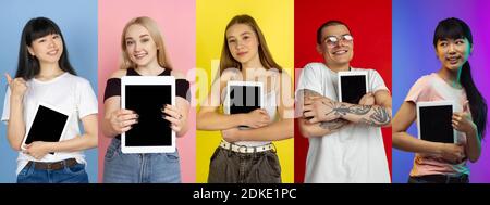 Collage di ritratti di 4 giovani emotivi su sfondo multicolore studio. Multietnico. Concetto di emozioni umane, espressione facciale, vendite. Visualizzazione di un tablet con schermo vuoto, studenti. Foto Stock