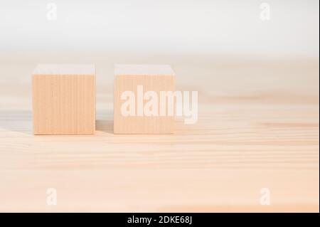 due cubi di legno per il tuo testo, icone, segni e simboli per creare i tuoi concetti creativi. Fock su cubi di legno vergini. Blocchi su tavolo di legno Foto Stock