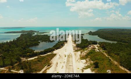 Costruzione della pista dell'aeroporto locale su un'isola tropicale. Costruzione di una striscia di atterraggio. Balabac, Palawan, Filippine. Foto Stock