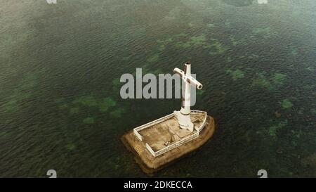 Croce cattolica nel cimitero affondata nel mare al tramonto, antenna fuco. Grandi crucafix segnando il sottomarino sunken cimitero, CAMIGUIN ISLAND Filippine. Foto Stock