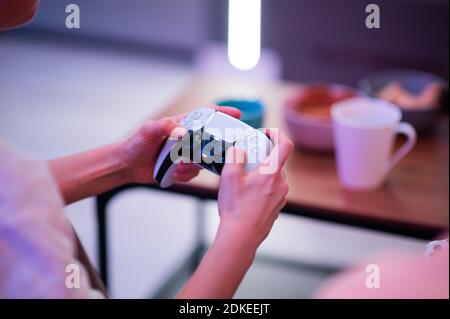 Ragazza che utilizza il nuovo controller wireless DualSense per PlayStation 5 Sony, che offre un feedback tattile coinvolgente, trigger dinamici adattativi e un integrato Foto Stock