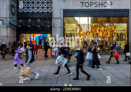 Londra, Regno Unito. 15 Dic 2020. Top Shop, parte del gruppo in lotta Arcadia, offre sconti enormi ai potenziali acquirenti di passaggio - Oxford Street, alla vigilia del terzo livello, e gli acquirenti sono ora fuori i negozi sono nuovamente aperti. Ma questi sono ancora tempi difficili per i rivenditori, in quanto cercano di recuperare dopo il secondo blocco di Coronavirus e la risposta al Tier 3 per Londra è poco oculata. Credit: Guy Bell/Alamy Live News Foto Stock