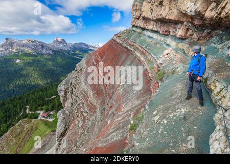 Giovane uomo di 22 anni lungo il percorso attrezzato Astaldi (caratteristico per le rocce colorate) ai piedi di Tofane, Cortina d'Ampezzo, Dolomiti, Belluno, Veneto, Italia Foto Stock