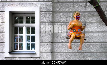 Scultura di una donna con maschera a Monaco in autunno. Foto Stock