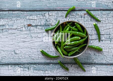 Vista dei peperoncini verdi in una ciotola. Peperoncini verdi comunemente usati nella cucina asiatica. Foto Stock