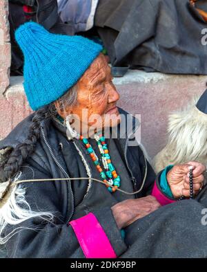 Lamayuru, India - 17 giugno 2012: Donne ladakhi dai capelli grigi più anziane in abiti tradizionali e gioielli tra la folla di osservatori che guardano lo yur buddista Foto Stock