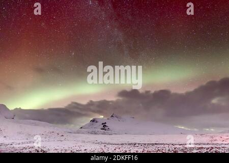 L'aurora boreale e le nuvole nel cielo stellato nelle alture innevate di Drumrunie, Scozia Foto Stock