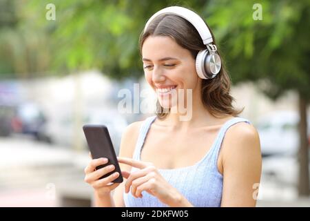 Buon teen ad ascoltare musica con smartphone e wireless cuffie Foto Stock