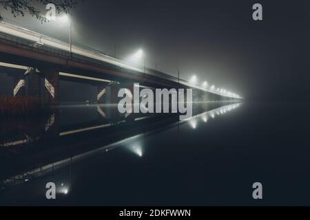 Ponte che si affievolisce in una nebbia notturna, ponte settentrionale, Voronezh, Russia. Foto Stock