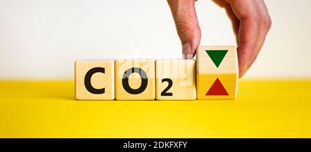 Simbolo modifiche CO2. Concetto 'CO2' su cubi e blocchi su uno sfondo bianco bello. La mano maschio cambia la direzione di una freccia che simboleggia t Foto Stock