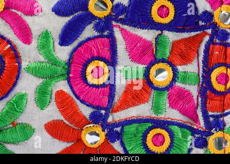 Colorato ricamo Kutchi su tela tessitura dont da artigiani. Lavori di filo fatti a mano, lavoro di specchio da Gujarat, India Foto Stock