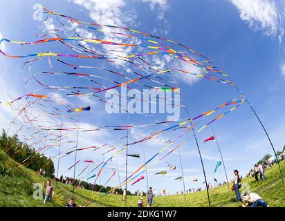 MOSCA, RUSSIA - 1 GIU: Fluttering nel vento nastri colorati e aquiloni colorati al festival di aquiloni con persone felici e bambini intorno Foto Stock