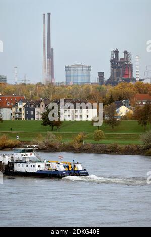 Duisburg, Renania Settentrionale-Vestfalia, Germania - paesaggio urbano nella zona della Ruhr con le navi della navigazione interna sul Reno di fronte agli edifici residenziali nel distretto di Laar e sul retro l'altoforno 8 da ThyssenKrupp Huettenwerk a Brukhausen Foto Stock