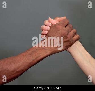 gesto della mano che non mostra alcuna discriminazione tra bianco e nero foto di scorta di sfondo scuro Foto Stock