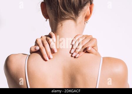 Donna dalla schiena con dolore al collo o alle spalle. Lesione o spasmo muscolare. Foto Stock