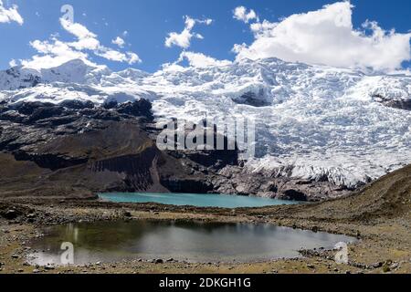 Enormi ghiacciai sulla faccia orientale della montagna di Ausangate che cade a laghi glaciali, escursione Ausangate, Perù, Sud America. Foto Stock