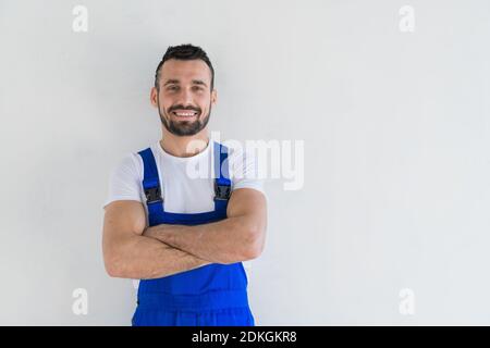 Un caposquadra si alza con le braccia ripiegate sul petto e. sorridente Foto Stock