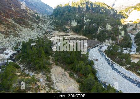 Scatti aerei di ruscello di montagna alla linea dell'albero dentro le alte montagne Foto Stock