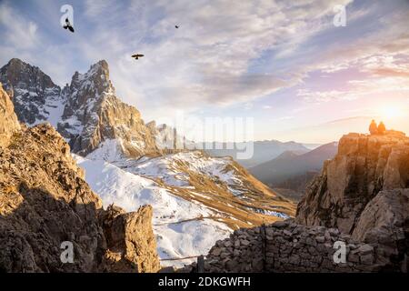 Italy, Trentino, Dolomites. two hikers at sunset sitting in front of Pale di San Martino, northern chain Stock Photo