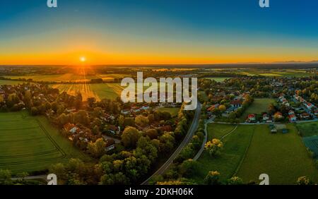 Tramonto su una piccola città, raggi di sole arancio illuminano le case. Bella ora di primavera Foto Stock