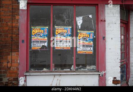 Poster pubblicitario Circus, vetrina vuota, incollata su finestre, negozio chiuso, derelict, vandalismo, fly poster, fastidio, comportamento antisociale . Foto Stock