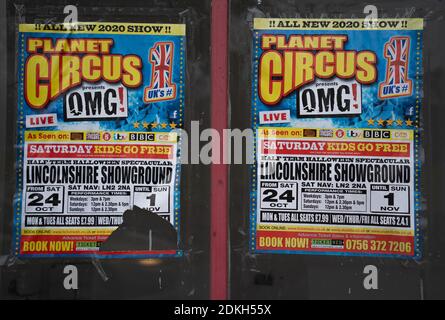 Poster pubblicitario Circus, vetrina vuota, incollata su finestre, negozio chiuso, derelict, vandalismo, fly poster, fastidio, comportamento antisociale . Foto Stock