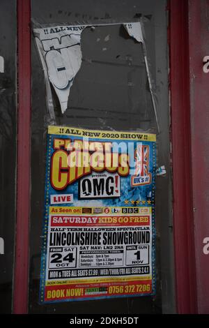 Poster pubblicitario Circus, vetrina vuota, incollata su finestre, negozio chiuso, derelict, vandalismo, fly poster, fastidio, comportamento antisociale . Foto Stock