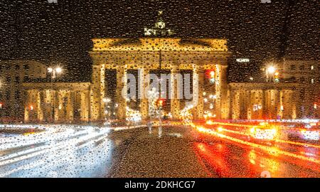 Berlino, Germania. 15 Dic 2020. La porta di Brandeburgo brilla dietro un parabrezza di un'auto coperta da gocce di pioggia. Credit: Peter Kneffel/dpa/Alamy Live News Foto Stock