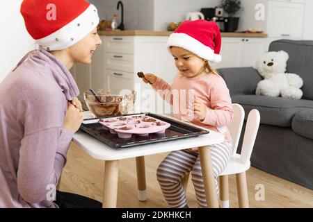 Madre con bambino che prepara i biscotti di festa a casa. Buon tempo in famiglia insieme Foto Stock