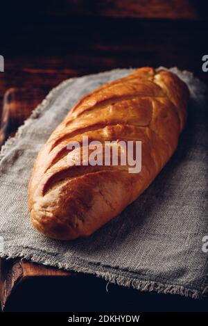 Una pagnotta di pane su una tavola di legno Foto Stock