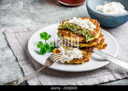 Zucchini frittelle di parmigiano con salsa e prezzemolo Foto Stock