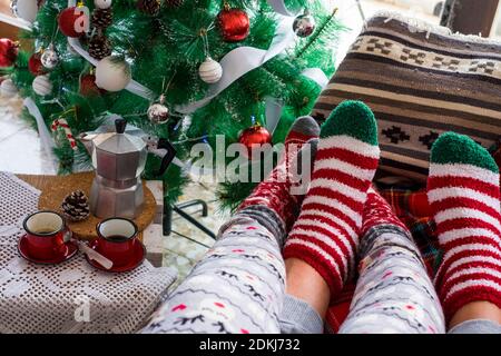 Primo piano di due calze rosse natalizie - concetto di amore e di vita insieme celebrare la vigilia di natale rilassante sul divano - persone in amore rapporto godendo inverno vacanze Foto Stock