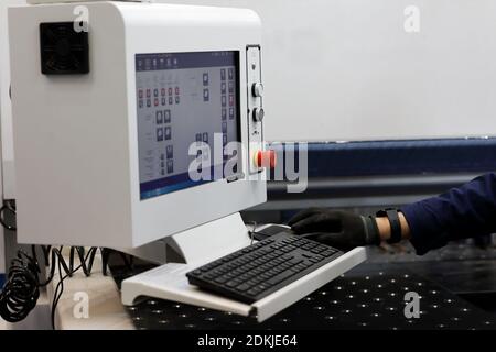 Metalworking machine operator at the control panel. Selective focus. Stock Photo