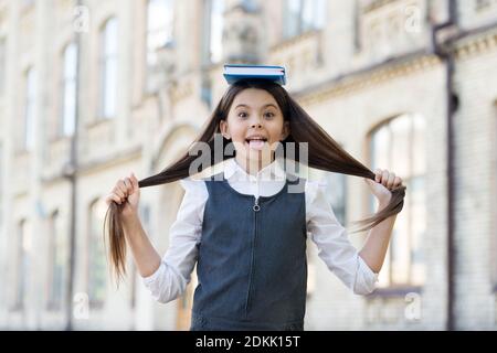 Libro insegna come creare acconciature da soli. I bambini tengono i capelli lunghi. Libro di cura dei capelli. Scuola di bellezza. Formazione per parrucchieri professionali. Corsi di taglio. Classi di styling e cura dei capelli. Foto Stock