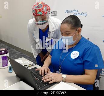 Miami, Stati Uniti. 15 Dic 2020. Da (L-R) Michelle Tenn-Hue, RN presso Jackson Health Systems, e Melissa Dominique, implementazione di sistemi presso Jackson Health Systems a Miami, Florida, rivedere l'uso del vaccino del Pfizer-biotech COVID-19 presso il Jackson Memorial Hospital a Miami, Florida martedì 15 dicembre 2020. Photo by Gary i Rothstein /UPI Credit: UPI/Alamy Live News Foto Stock