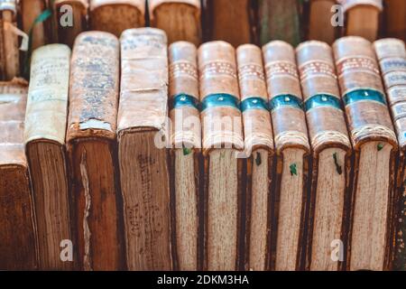 Vecchi libri vintage pile con coperture marroni giacenti su scaffale al mercato europeo di strada. Pila di libri marroni usati. Libreria retrospettiva. Francia - Foto Stock